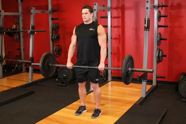 Athlète en fin de soulevé de terre dans une salle de musculation